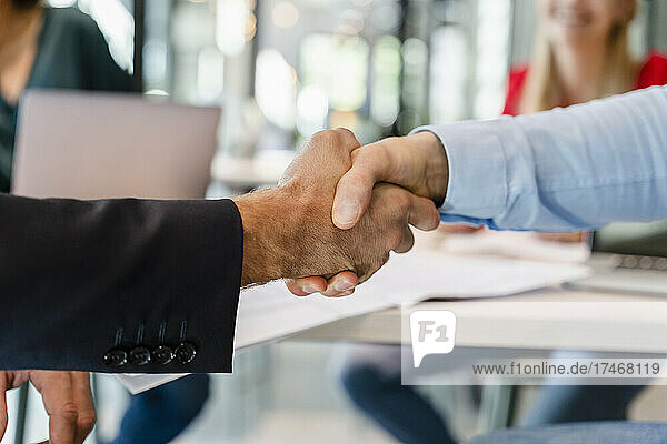 Businessmen doing handshake in meeting at office