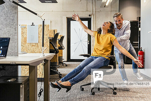 Happy businesswoman playing with coworker in office