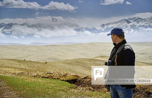 Man with camera looking at mountains