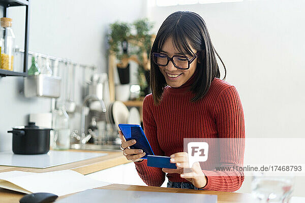 Smiling businesswoman doing online payment through credit card