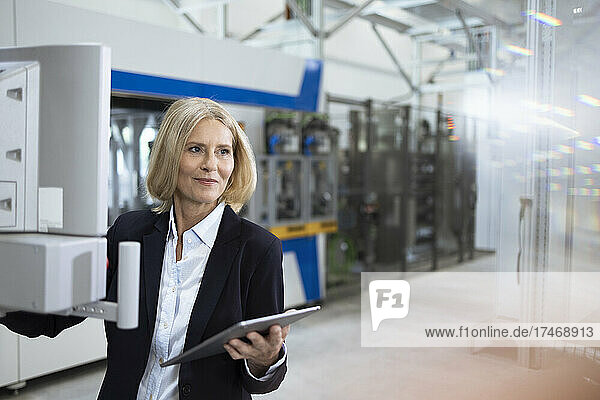 Mature businesswoman with digital tablet working in factory