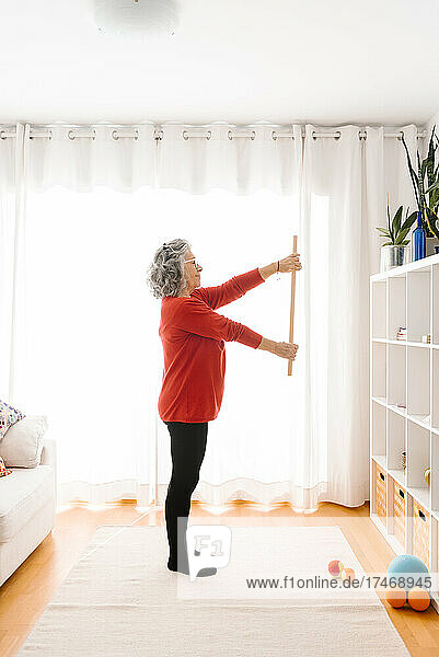 Senior woman practicing gymnastic at home