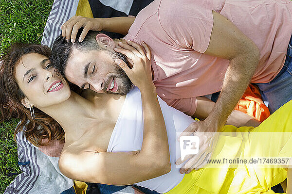 Young couple resting together on picnic blanket
