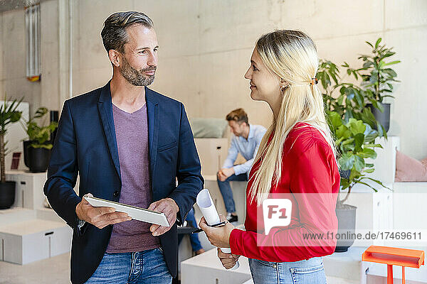 Blond businesswoman having discussion with colleague in office