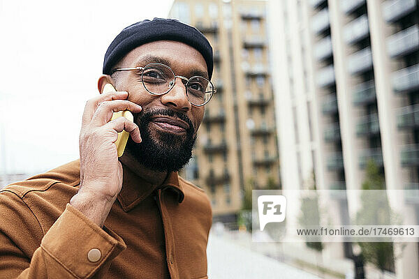Smiling bearded man talking on smart phone
