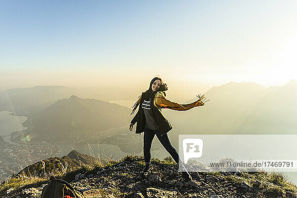 Young man dancing with scarf on mountain peak at Orobie Alps  Lecco  Italy