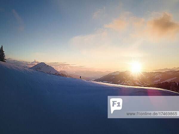 Woman skiing on snowcapped mountain slope at sunrise  Schonkahler  Tyrol  Austria