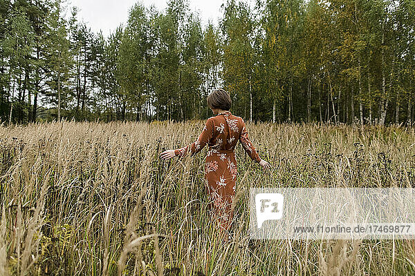 Frau in Kleid läuft inmitten von Feldfrüchten