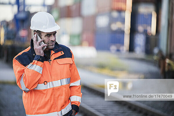 Male worker talking on smart phone at dock