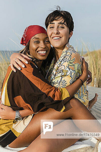 Happy lesbian woman embracing girlfriend at beach