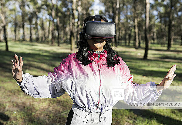 Woman with virtual reality headset gesturing at park