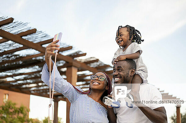 Woman taking selfie with family by roofing