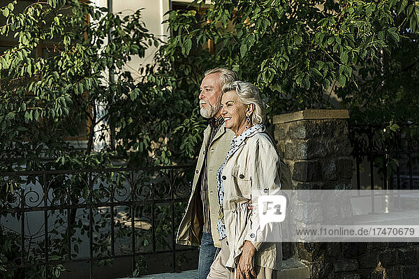 Smiling couple walking together by retaining wall