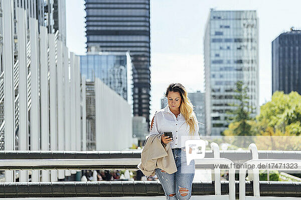 Businesswoman using mobile phone in city