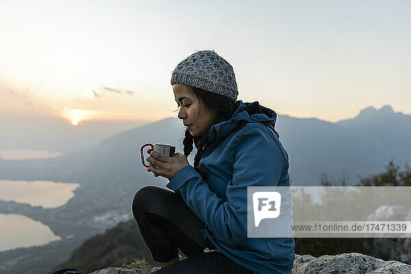 Woman having coffee on mountain
