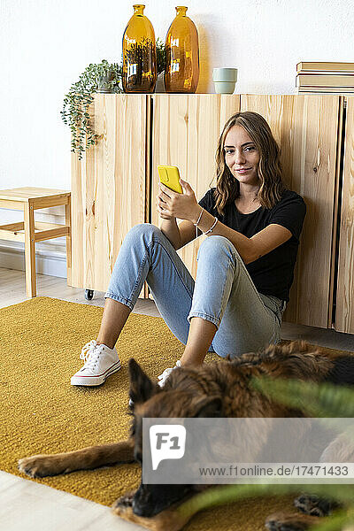 Smiling woman by dog at home