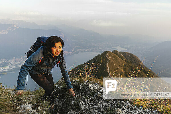 Smiling hiker climbing on mountain