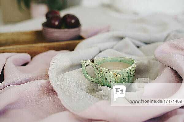 Coffee cup on bed at home