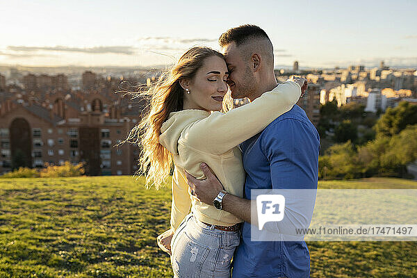 Boyfriend hugging girlfriend on hill