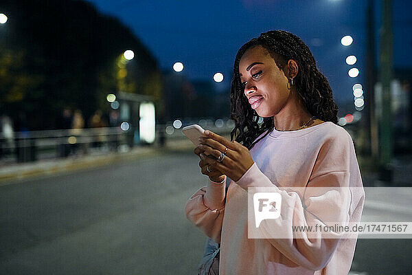 Young woman using smart phone at night