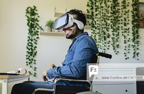 Smiling disabled businessman using virtual reality headset at home