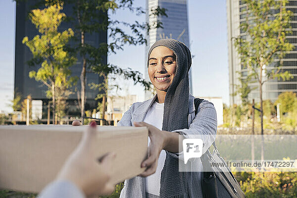 Smiling businesswoman receiving box from female friend