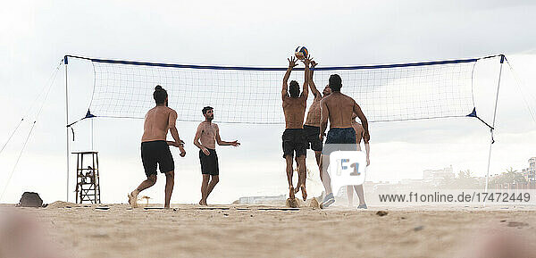 Friends playing beach volleyball on vacation