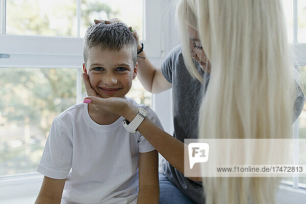 Loving blond mother sitting with son at home