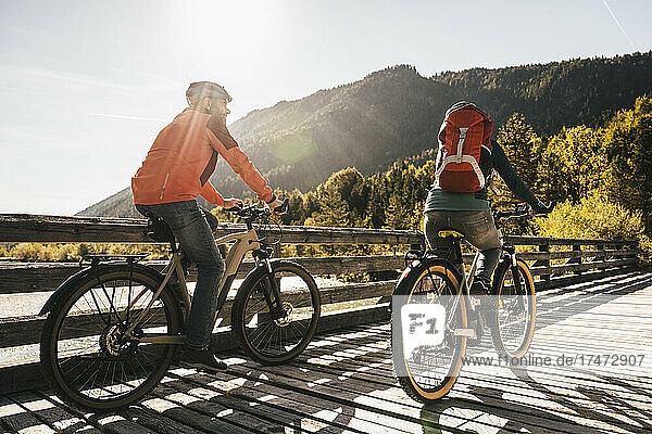 Paar fährt an einem sonnigen Tag Fahrrad an der Brücke