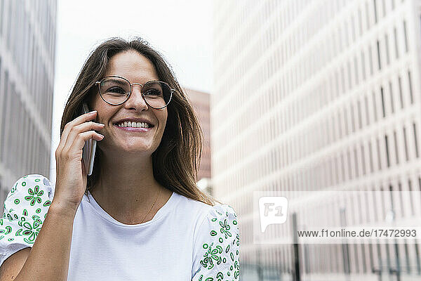 Happy young businesswoman talking on smart phone