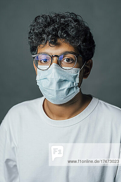 Man with protective face mask against gray background
