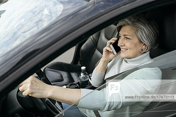 Woman talking on mobile phone while driving car