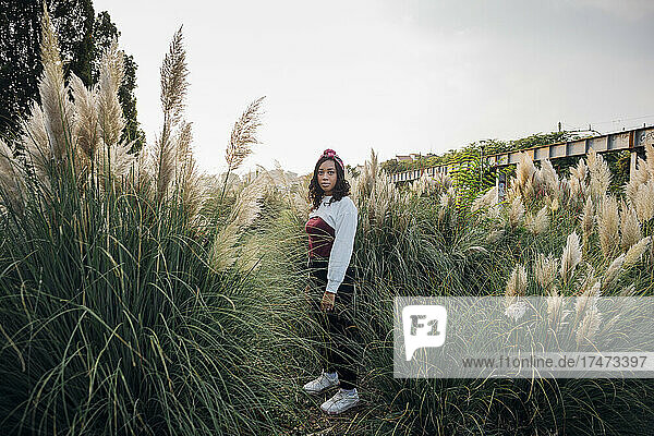 Woman with headband standing amidst grass