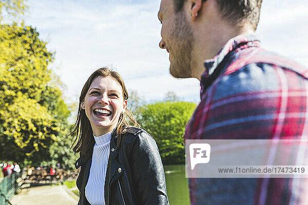 Happy woman talking to friend in park