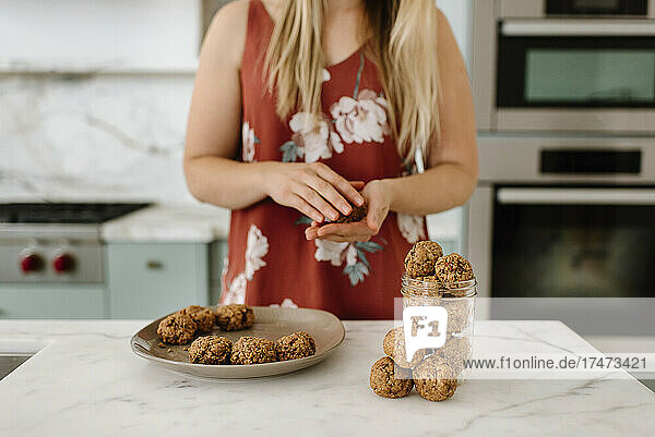 Female nutritionist preparing cookie in kitchen