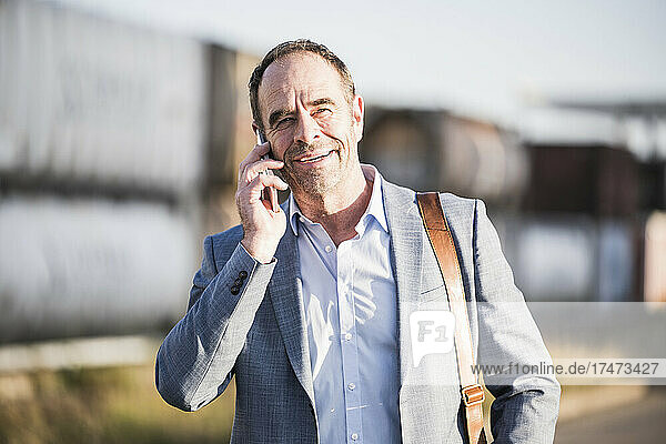 Smiling businessman talking over mobile phone