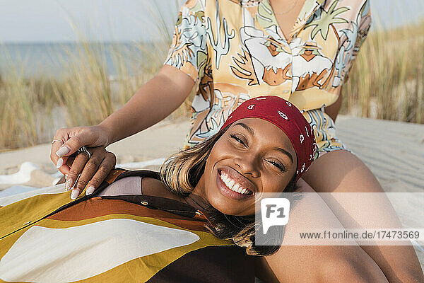 Smiling lesbian woman spending leisure time with girlfriend at beach