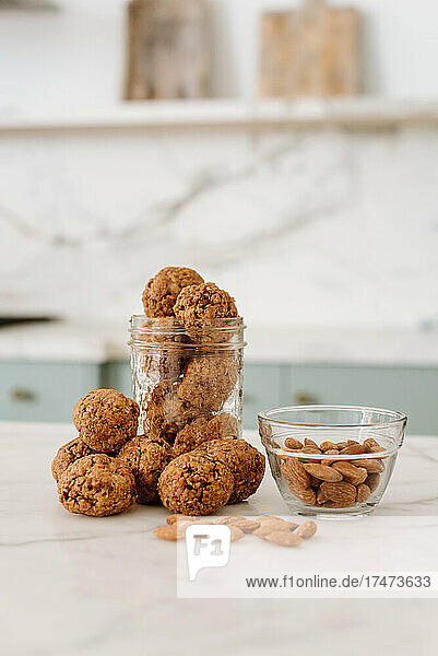 Homemade cookies by almonds in bowl kept at kitchen counter