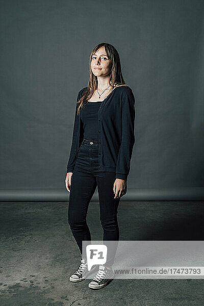 Woman in black casuals standing in front of gray backdrop