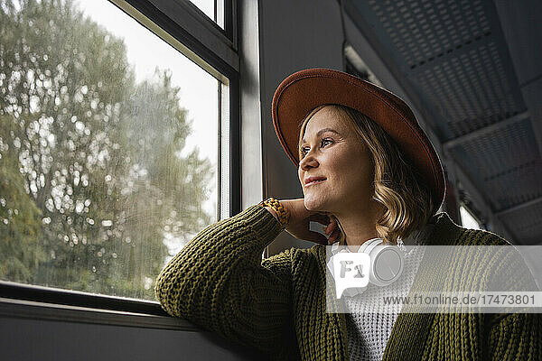 Frau schaut während der Zugfahrt durch das Fenster