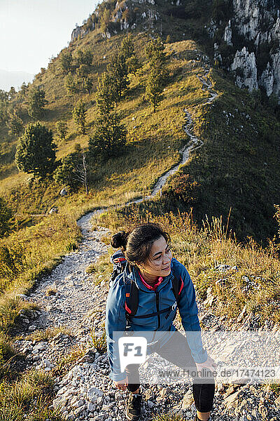 Young woman smiling while hiking on mountain