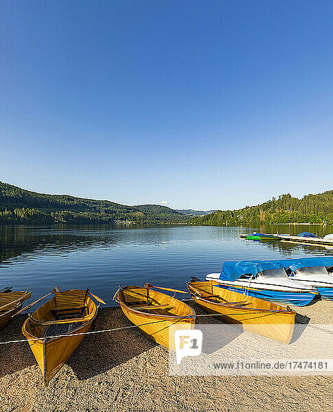 Clear sky over rowboats left on shore of Titisee lake