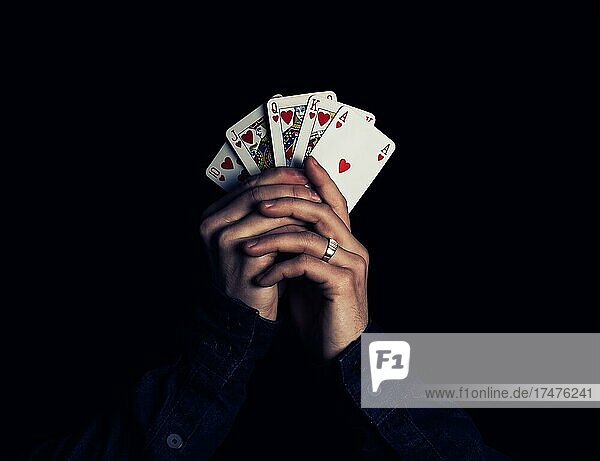 Poker  Mann hält Spielkarten mit der stärksten Kombination  Royal Flush  in den Händen