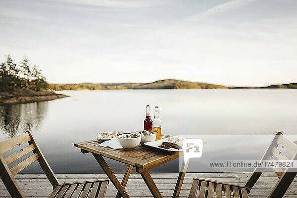 Essen auf dem Tisch am See gegen den Himmel angeordnet