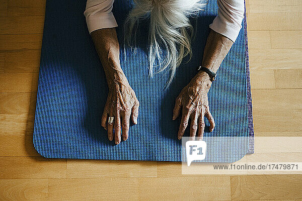 High angle view of senior woman exercising on mat at home