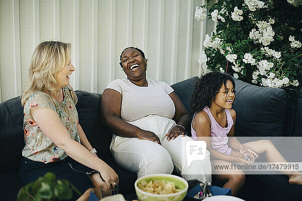 Fröhliche Mütter lachen bei einer Party im Hinterhof