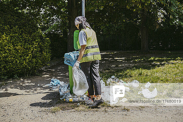 Junge Umweltschützerin  die Plastikmüll in den Mülleimer wirft