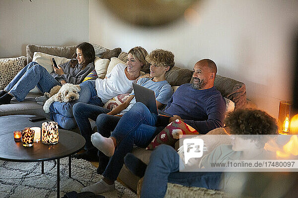 Lächelnde Familie sitzt auf dem Sofa im Wohnzimmer zu Hause
