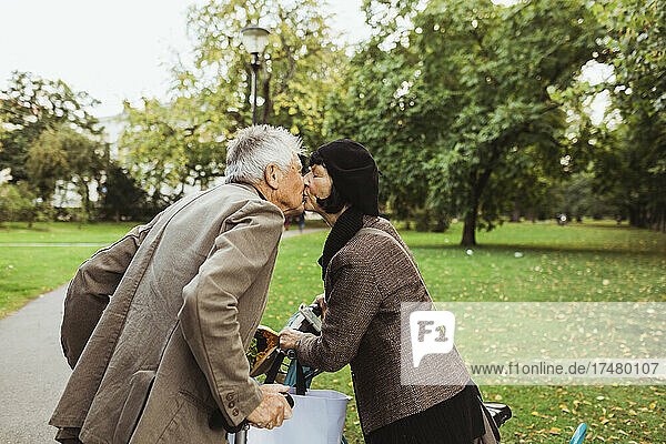 Älteres Paar küsst sich auf den Mund im Park im Urlaub