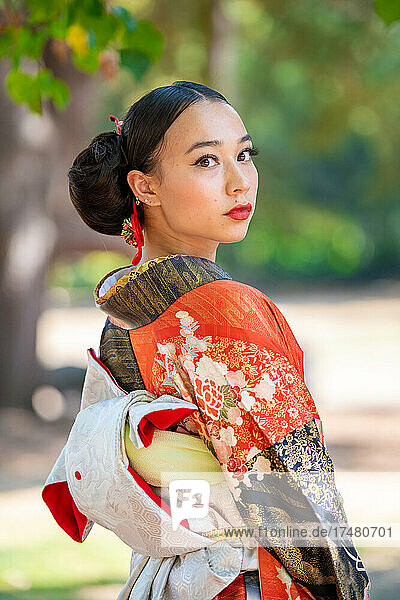 Portrait of woman wearing kimono standing in park